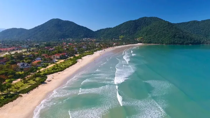Vista panorâmica da praia do sapê ubatuba com mar calmo e pôr do sol