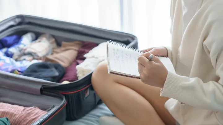 Mala aberta com roupas dobradas, acessórios de viagem e itens pessoais organizados