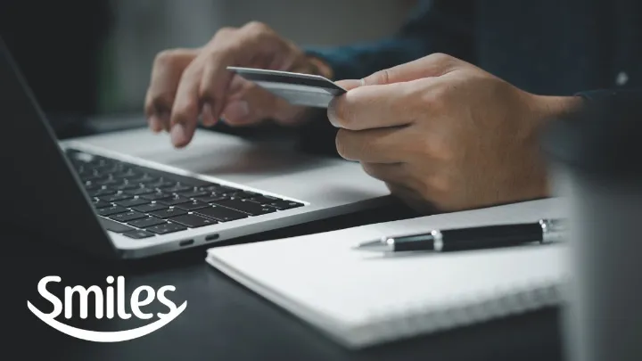 Cartão de embarque em mãos destacando milhas smiles