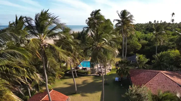 Fachada de pousada barata em São Miguel dos Milagres com árvores ao redor