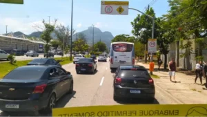 Avenida movimentada com carros e ônibus na Barra da Tijuca.